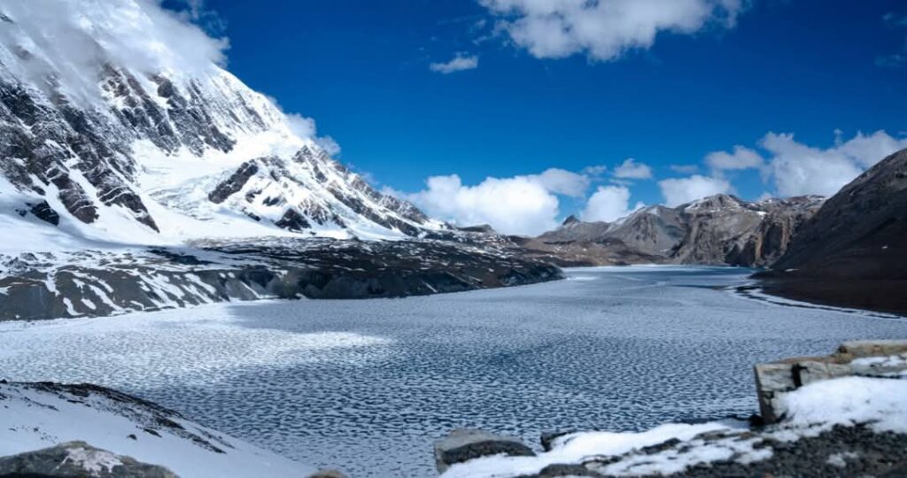 Tilicho Tal Lake from above with blue water and snow-capped peaks